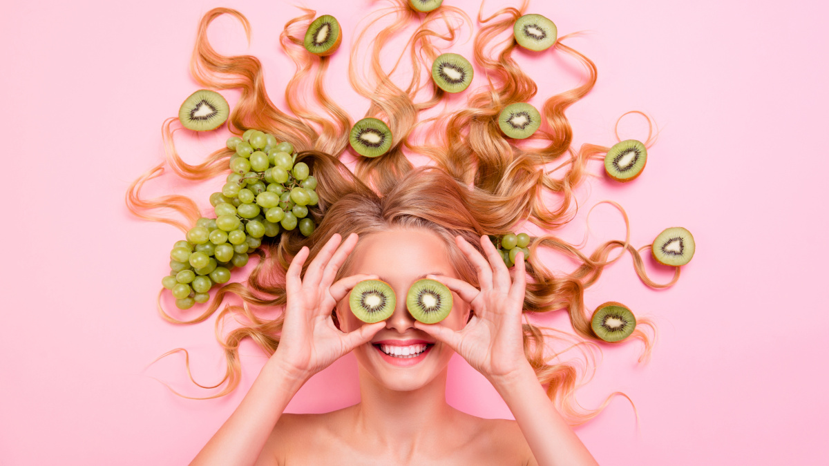 Donna sorridente con cibo antiossidante tra i capelli