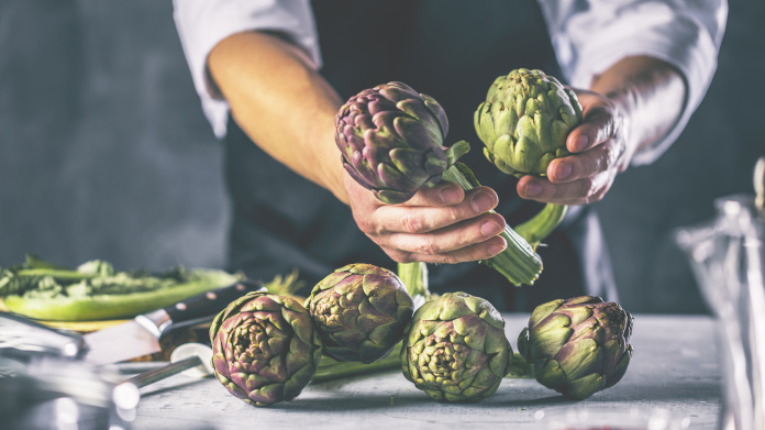 A chef holding some artichokes