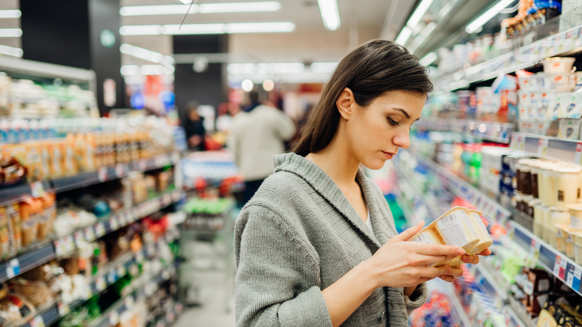 Anaemic woman in a shop checking a food product’s nutritional content 