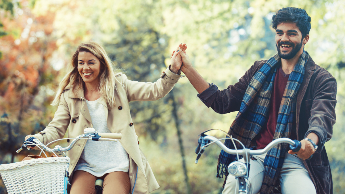 Pareja enérgica en bicicleta en el bosque en otoño