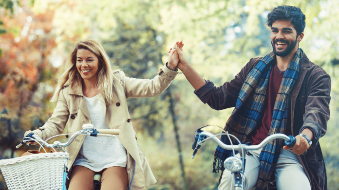 Couple énergique à vélo dans la forêt en automne