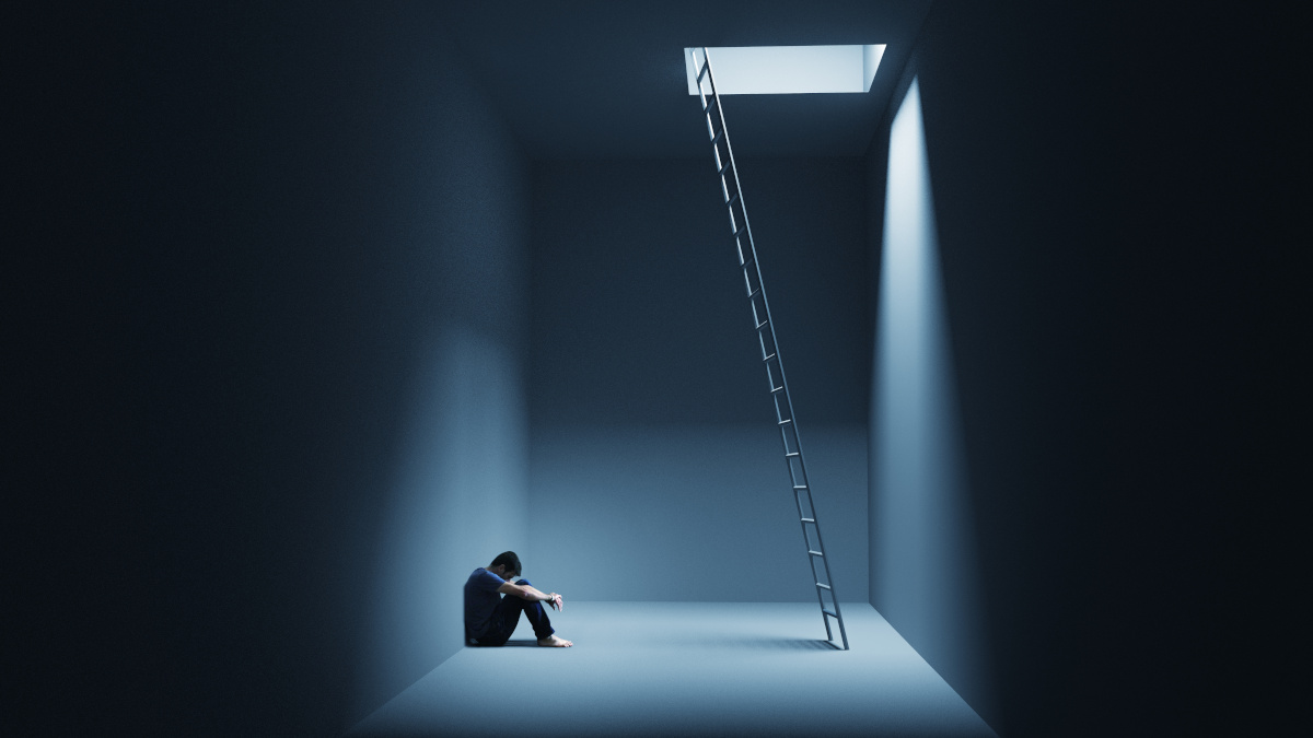 Homem com uma crise de ansiedade sentado perto de uma escada