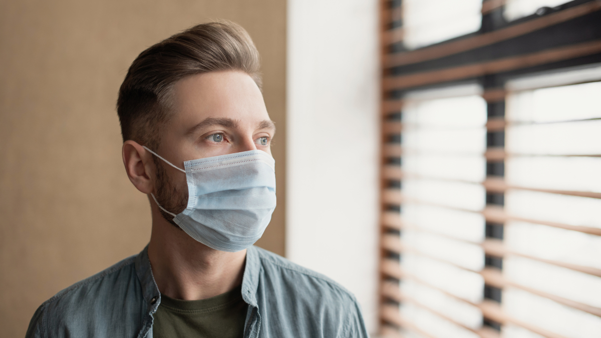 Depressieve man met mondmasker tijdens COVID-19-pandemie