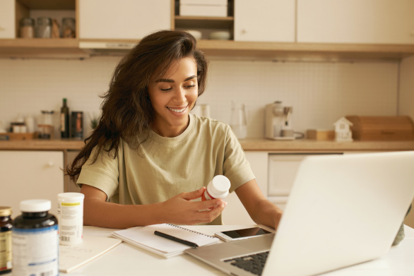 Mulher jovem a escolher o seu suplemento de multivitaminas