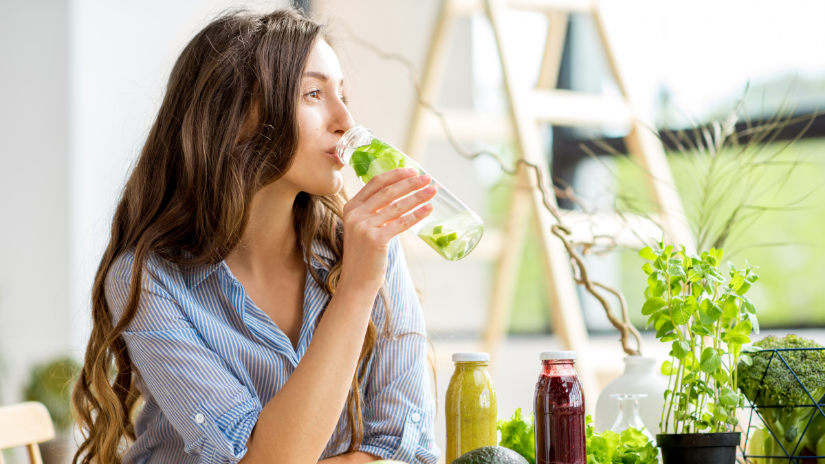 Jonge vrouw die een detox-sapje drinkt