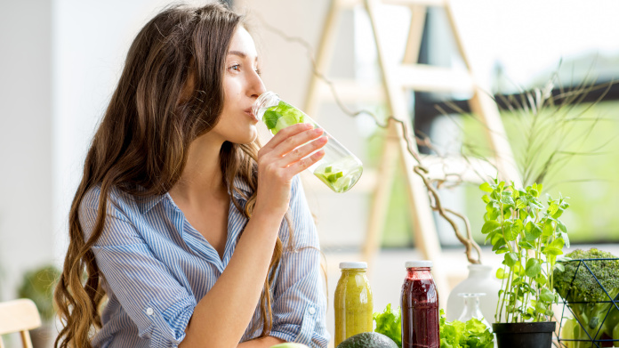 Mulher jovem a beber um sumo detox