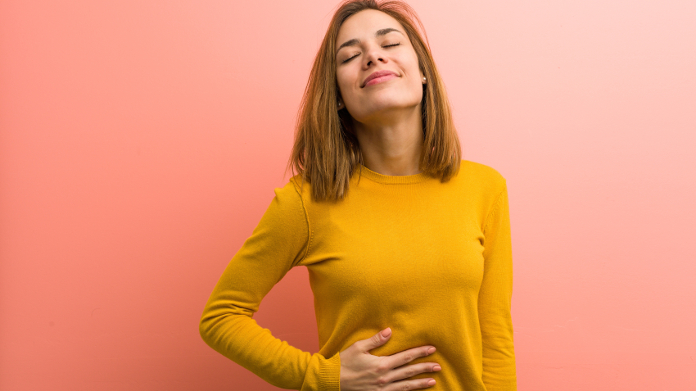 Mulher relaxada a digerir a sua refeição