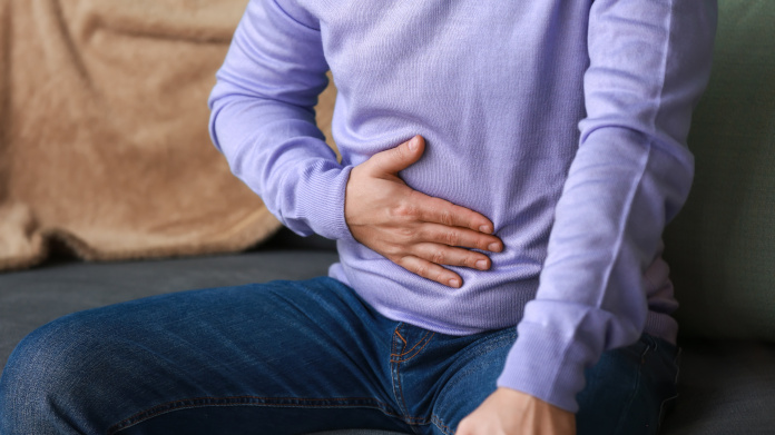 Seated man suffering from excessive flatulence