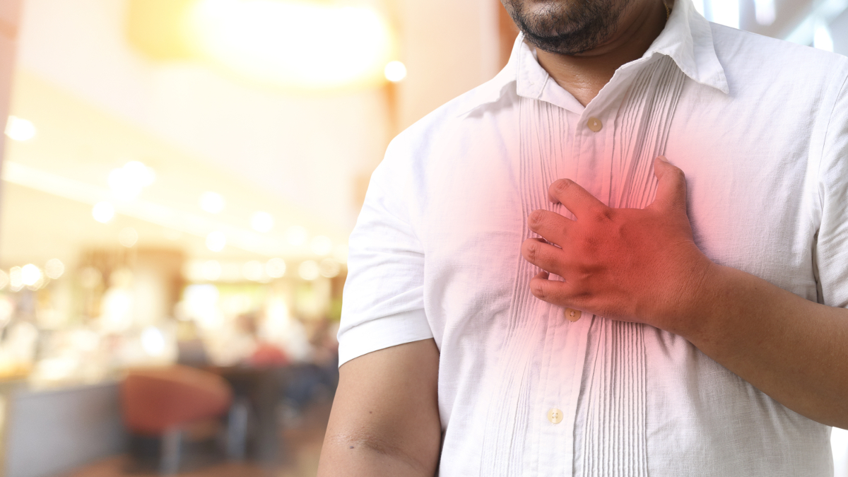 Homem em camisa com uma dor forte no peito