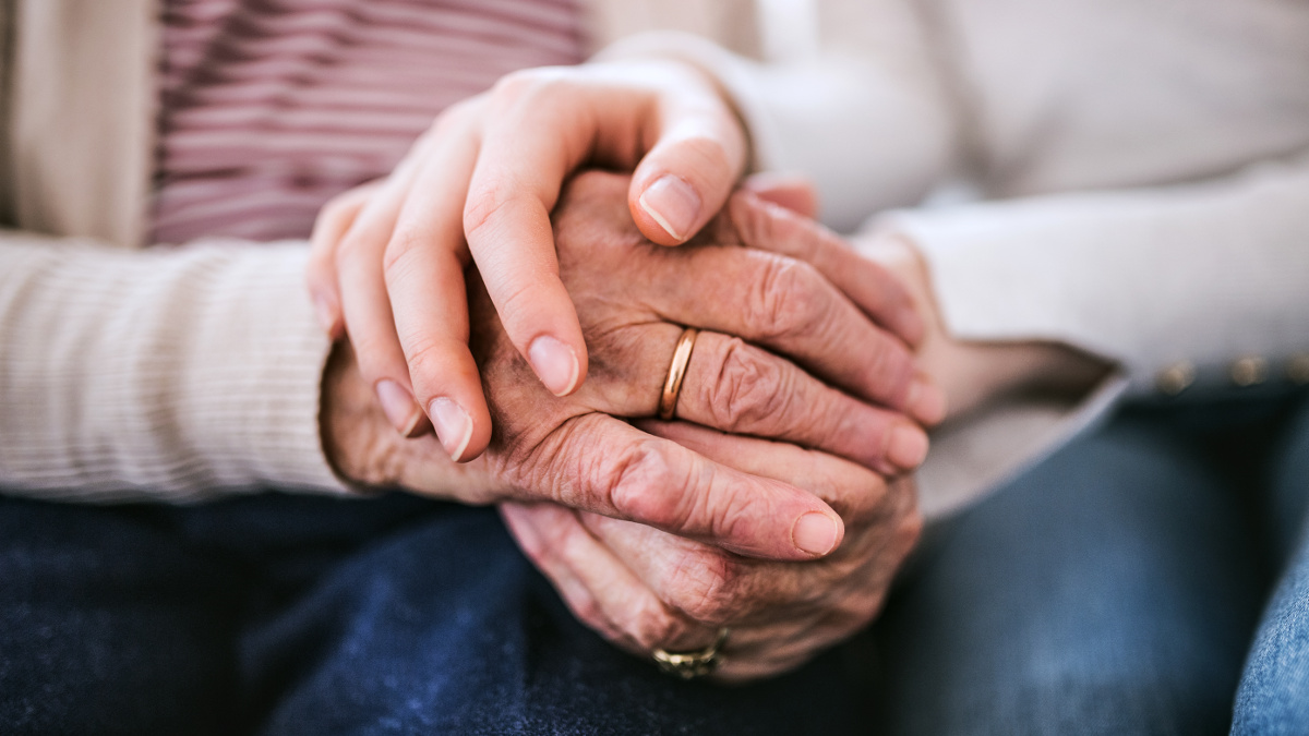 Alterungserscheinungen an den faltigen und fleckigen Händen eines älteren Menschen
