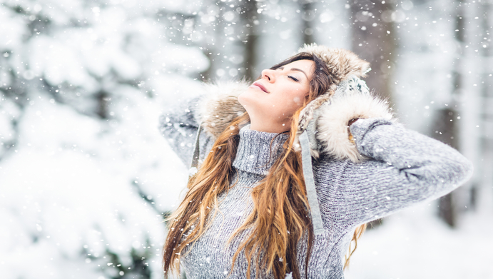 Eine Frau genießt den Wald im Winter