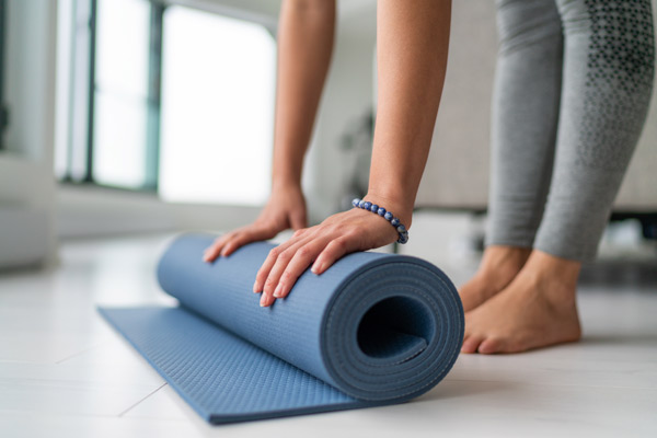 woman rolling a yoga mat