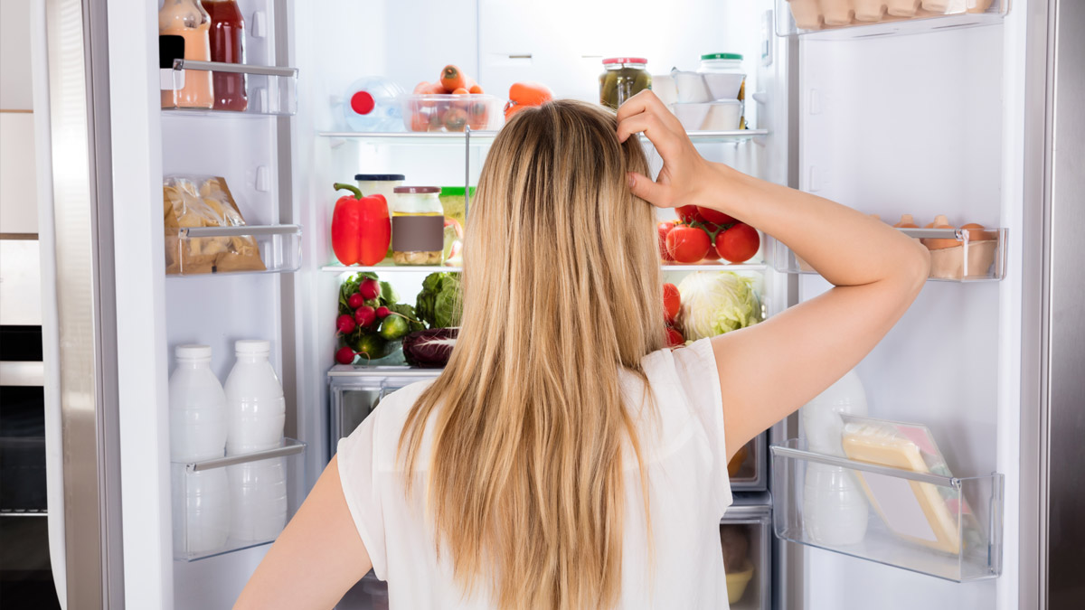 Fotografia di una persona che cerca qualcosa in frigo