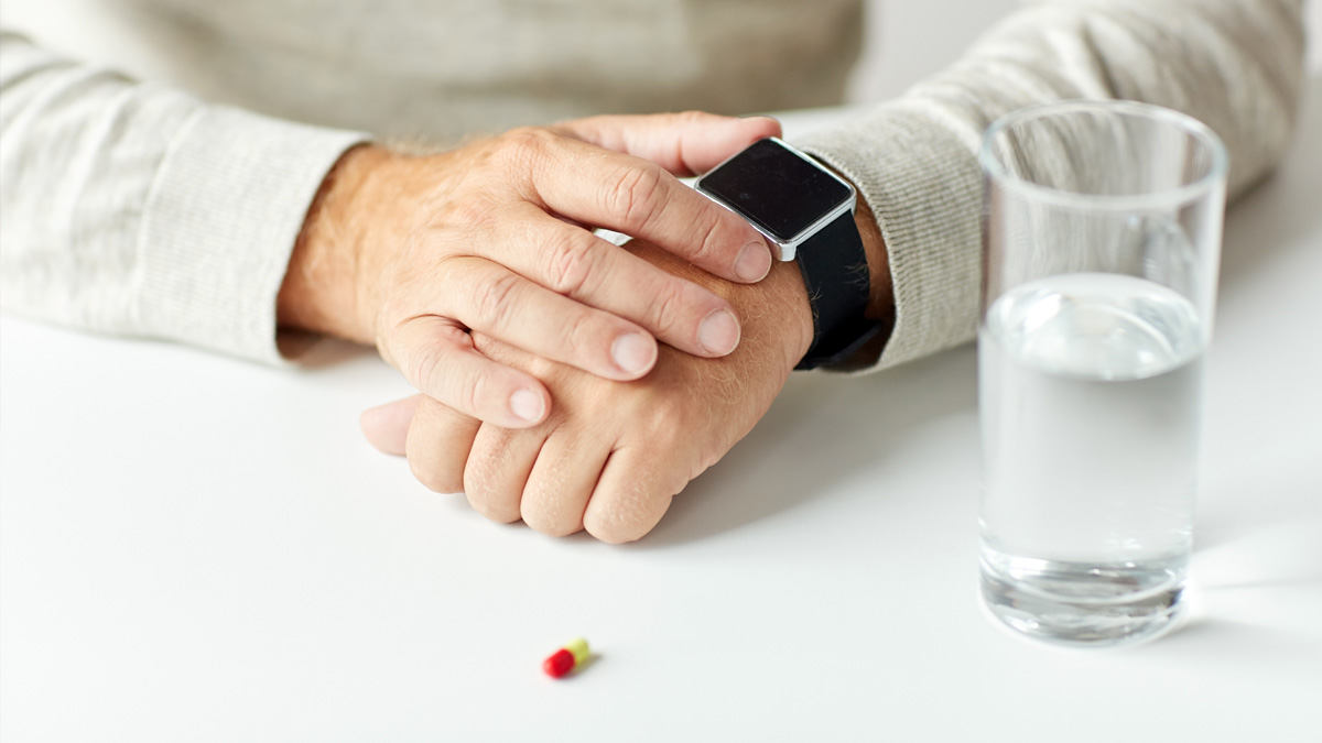 Tablet, glas water en horloge