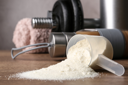 whey protein em pó e halteres