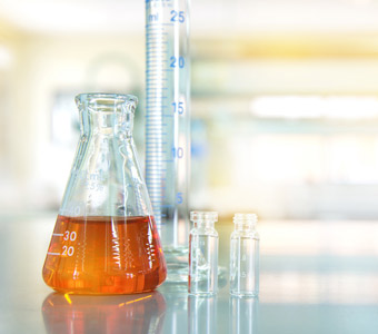 Laboratory glassware with orange liquid